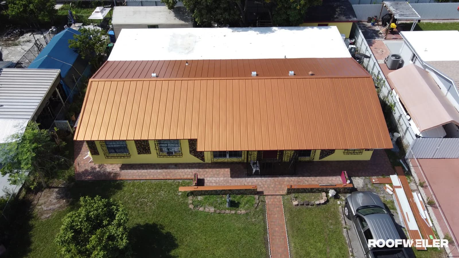 Aerial drone photo of a completed standing seam metal roof replacement on a single-family home in Miami Gardens, FL by Roofweiler